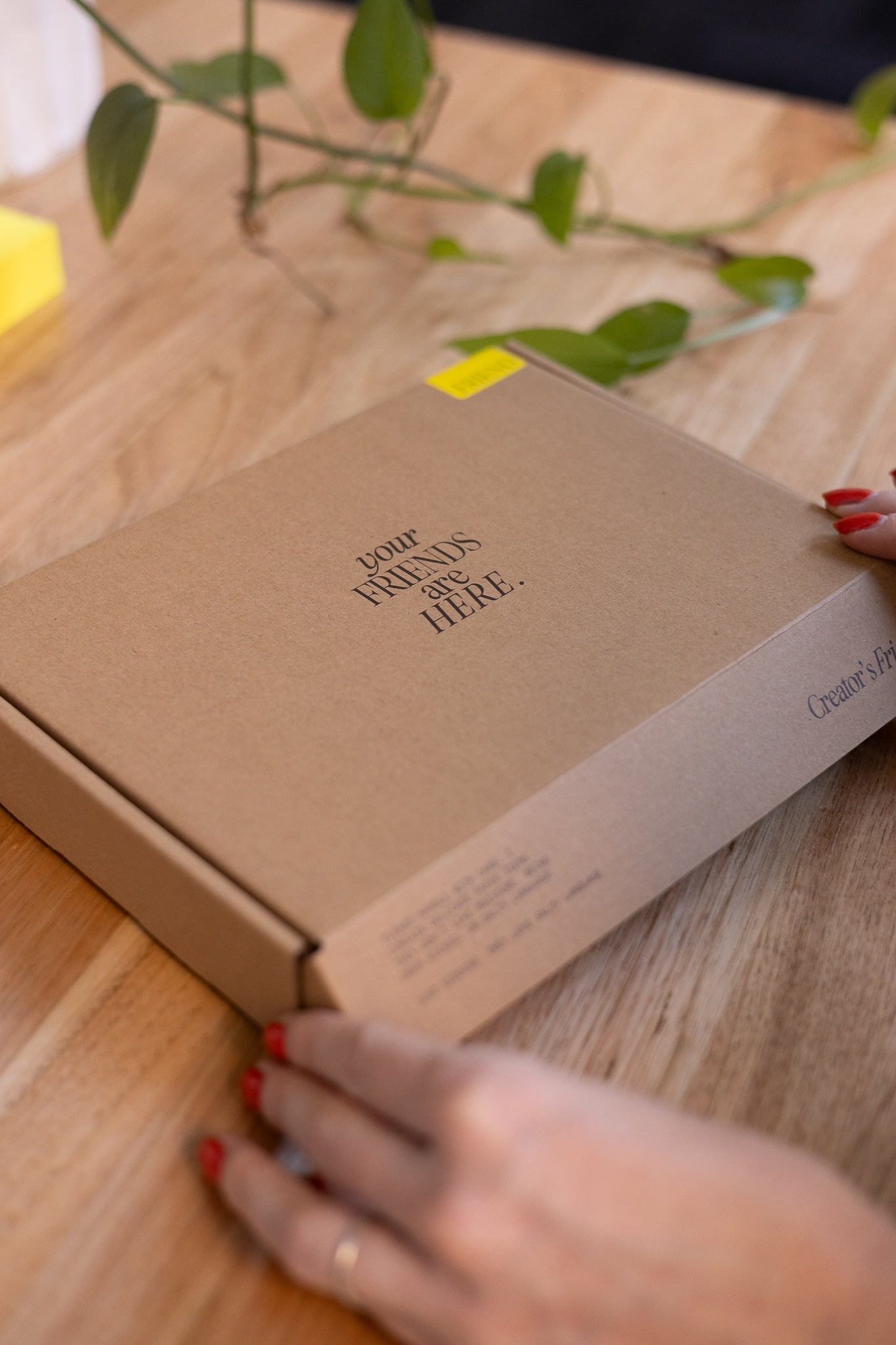 Brown box with 'Your Friends Are Here' text on a wooden surface