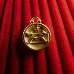 Gold Sagittarius pendant on a red textured background
