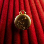 Gold pendant with Aquarius Constellation on a red textured background