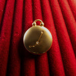 Gold pendant with Aries Constellation on a red textured background