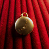 Gold pendant with Aries Constellation on a red textured background