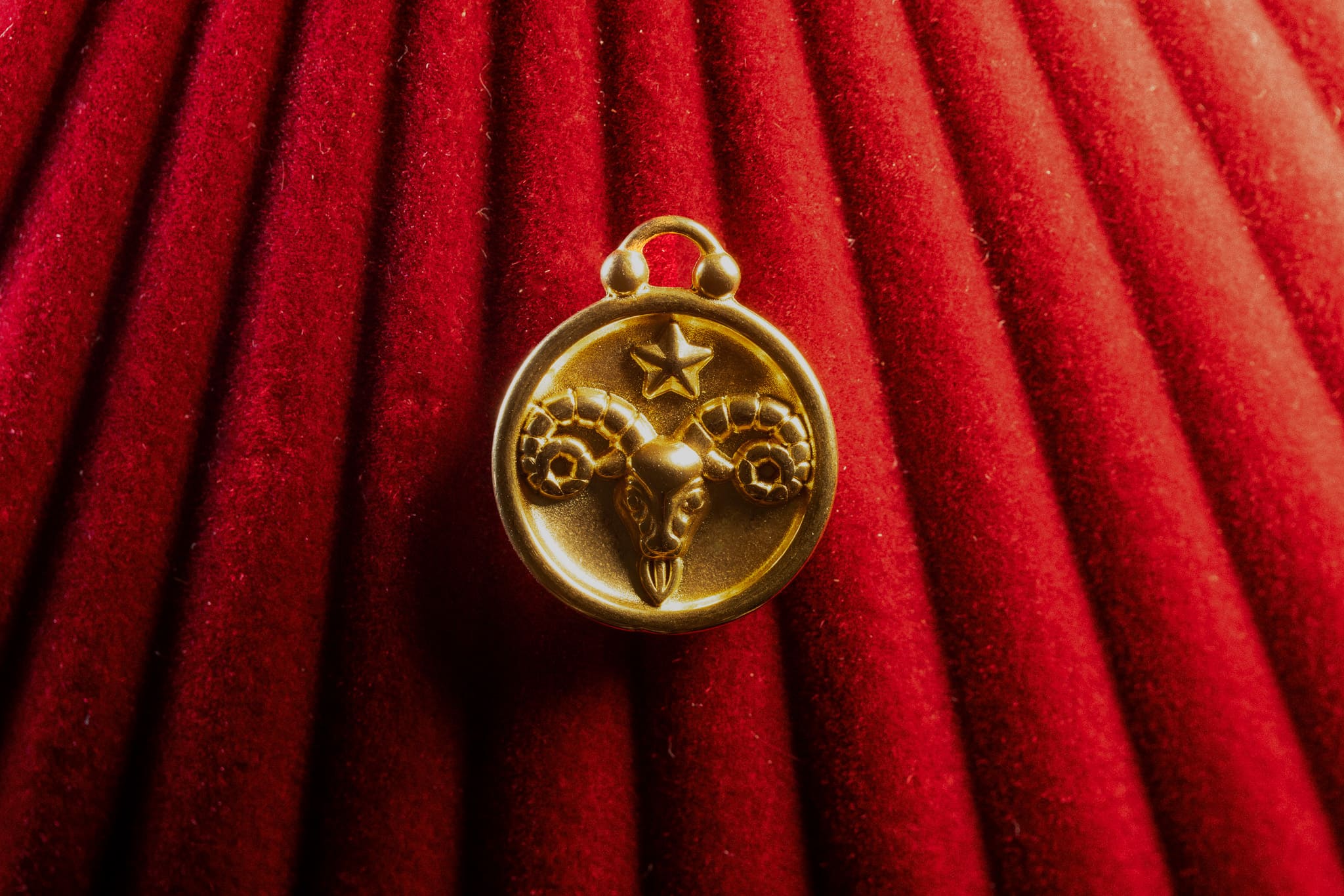 Aries pendant a red textured background