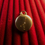 Gold Pendant with a Cancer Constellation on a red textured background
