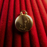 Gold pendant with Scorpio Constellation on a red textured background