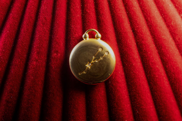 Gold Pendant on a Taurus Constellation on a red textured background
