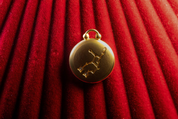 Gold Pendant with a Virgo Constellation on a red textured background