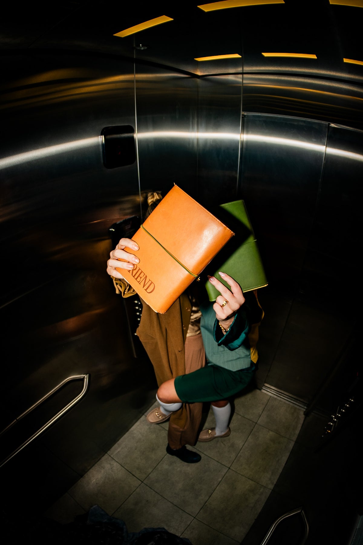Saddle Brown notebook folio wrapped around the vintage olive notebook folio in an elevator